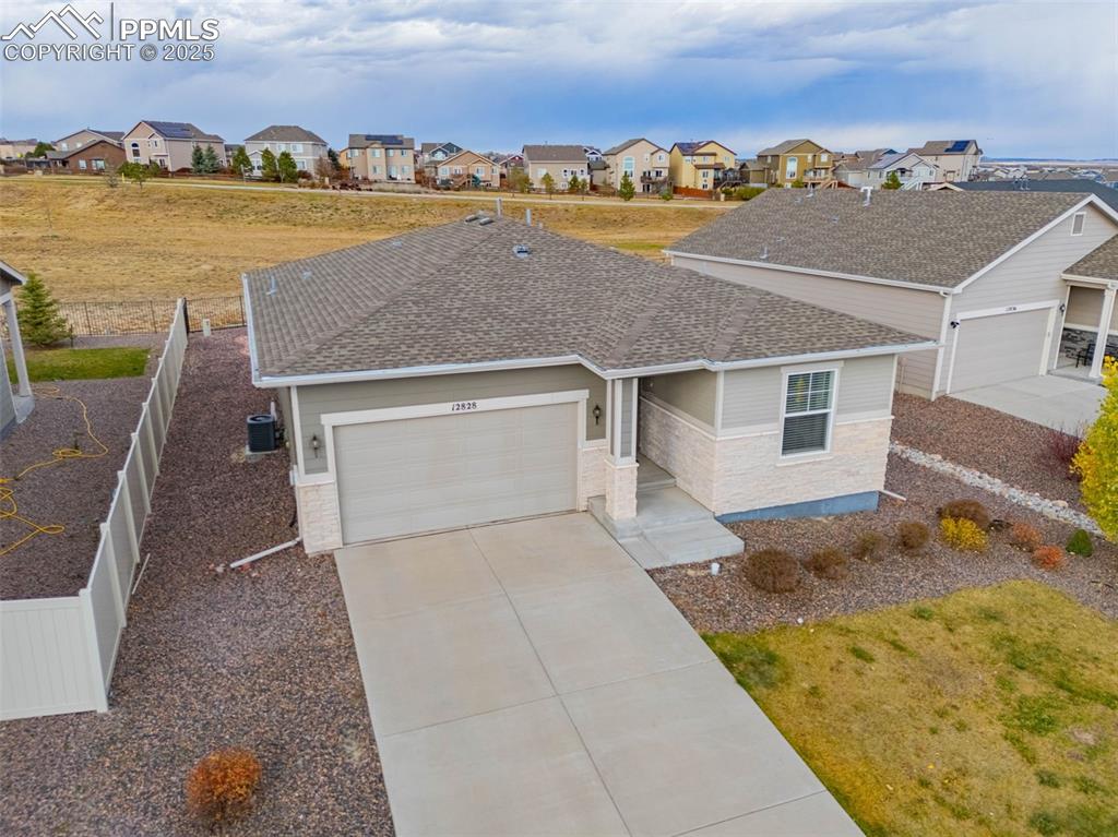 Image 3 of 37: View of front of home with a garage, roof with shingles, stone siding, driv