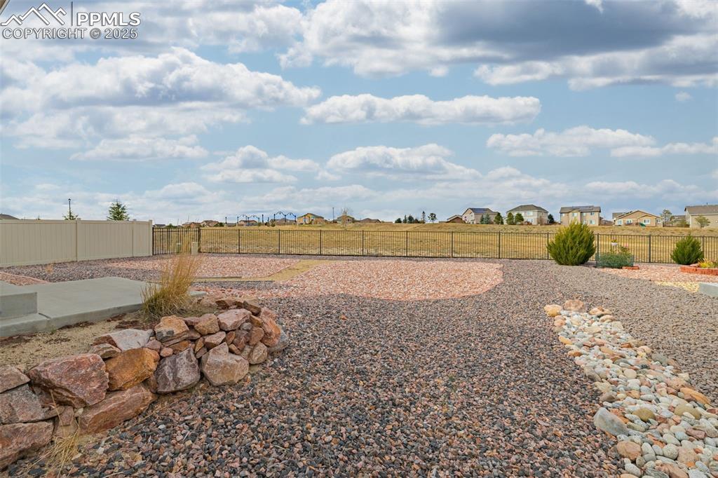 Image 35 of 37: Fenced backyard with a residential view