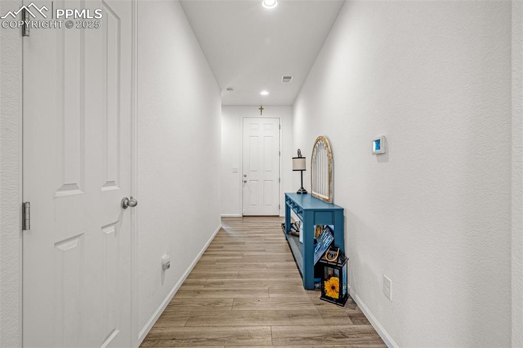 Image 6 of 37: Hall with light wood finished floors and recessed lighting