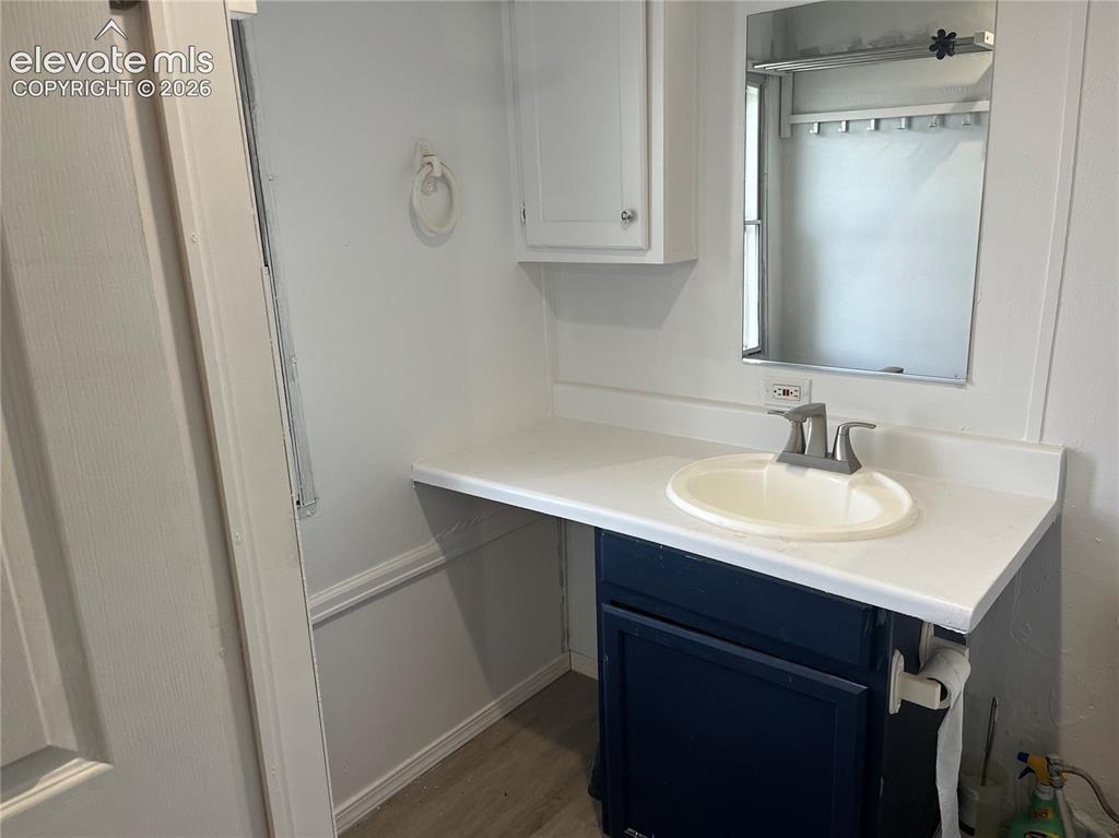Image 13 of 14: White vanity countertop with an integrated sink, blue-painted lower cabinet
