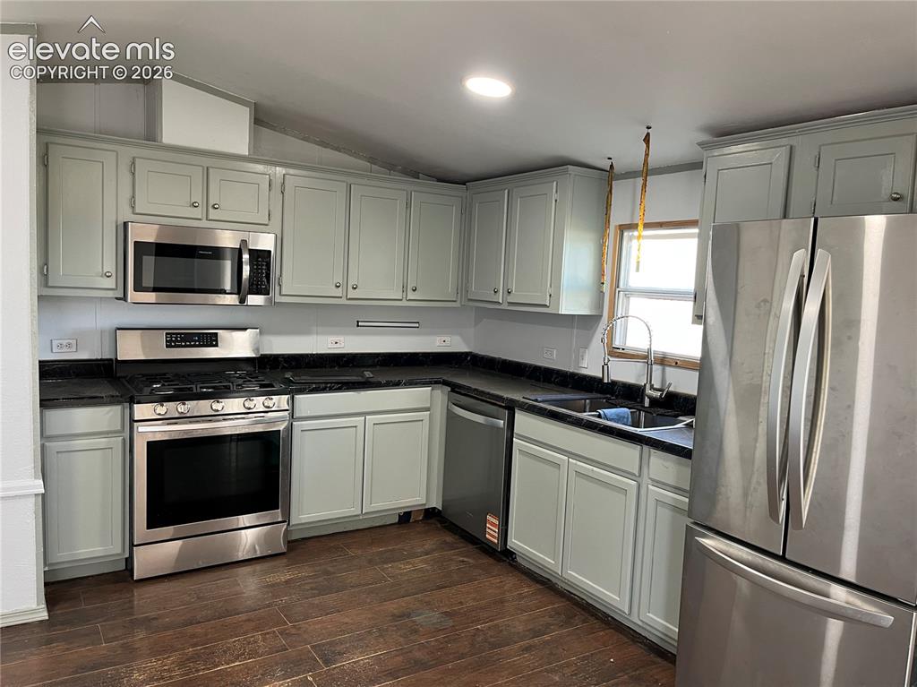 Image 7 of 14: Kitchen with wood-finish flooring, light-toned cabinetry, stainless steel a