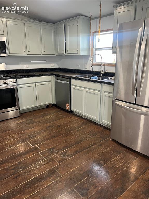 Image 9 of 14: Spacious kitchen featuring wood-finish flooring, light-toned cabinetry, dar