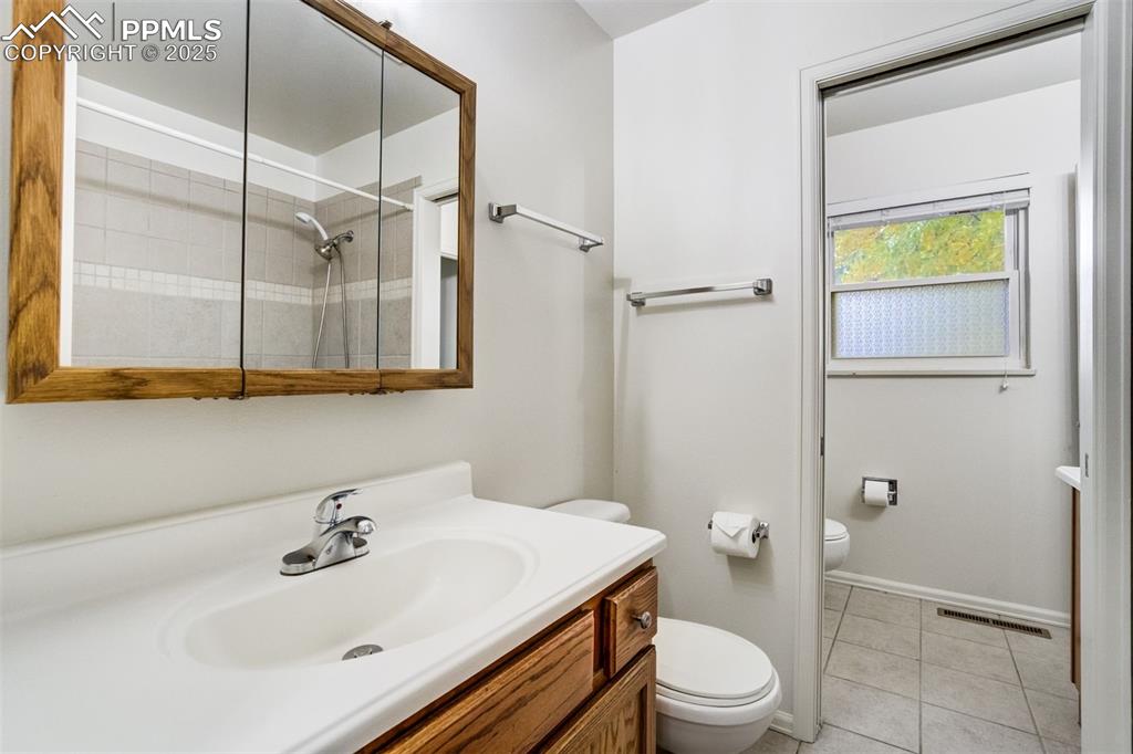 Image 19 of 44: Full hall bath with privacy door into primary bath