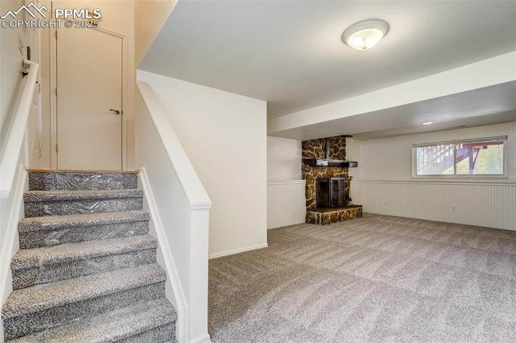 Image 22 of 44: Stairs from front entry and from garage, down to family room