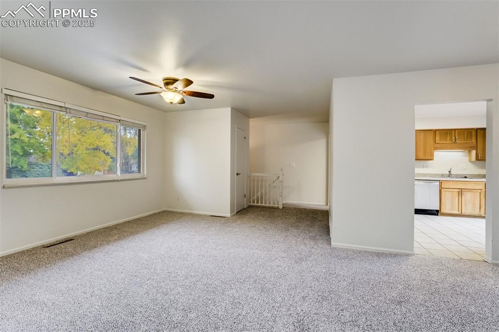 Image 4 of 44: Entry to living room showing the entry stairs and kitchen