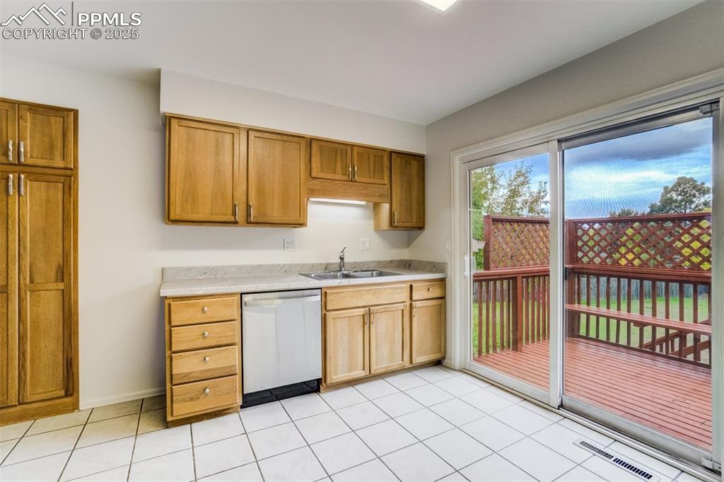 Image 9 of 44: Sink and pantry unit with slidiing glass door to deck
