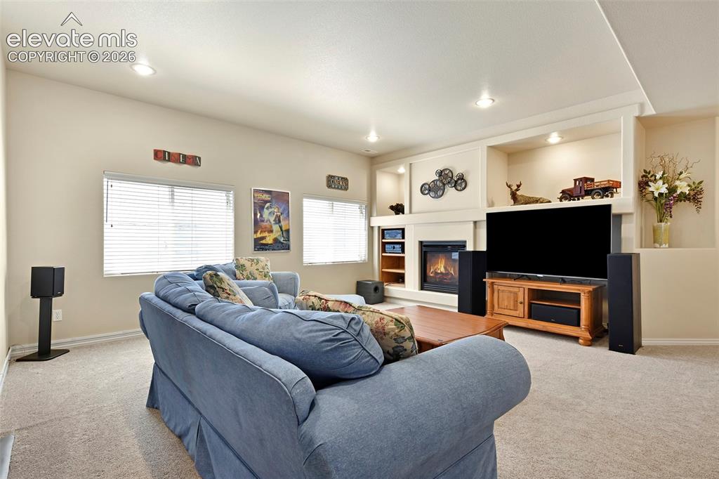 Image 33 of 46: Lower level Rec Room with built-ins and gas fireplace