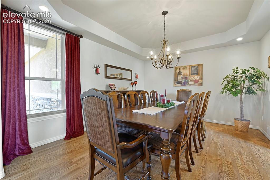 Image 5 of 46: Formal Dining Room with hardwoods and try ceiling