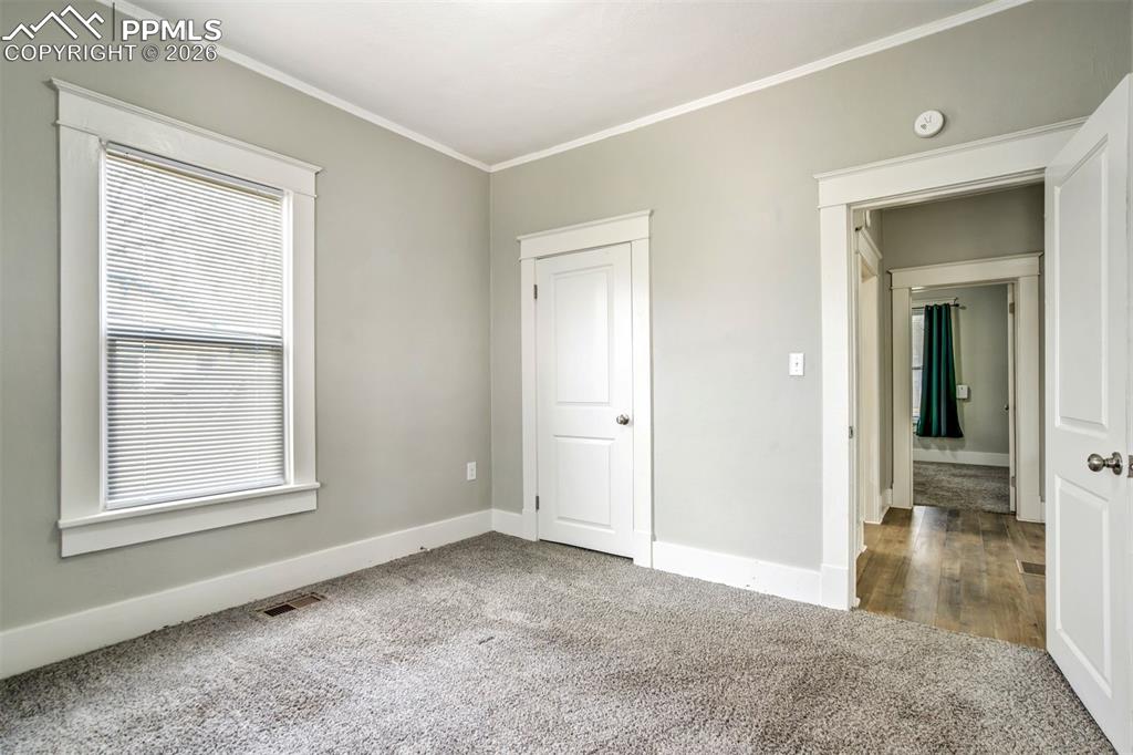 Image 10 of 38: Bright and inviting bedroom featuring fresh neutral paint, plush carpeting,