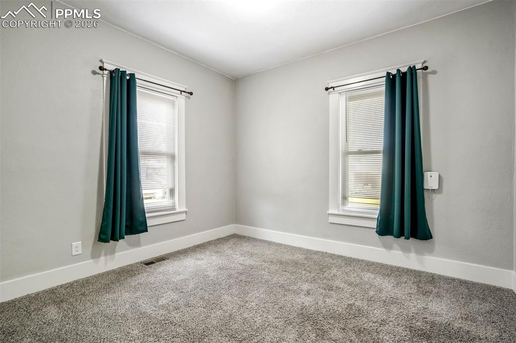 Image 12 of 38: Cozy bedroom with clean finishes, newer carpet, and ample wall space. Ideal