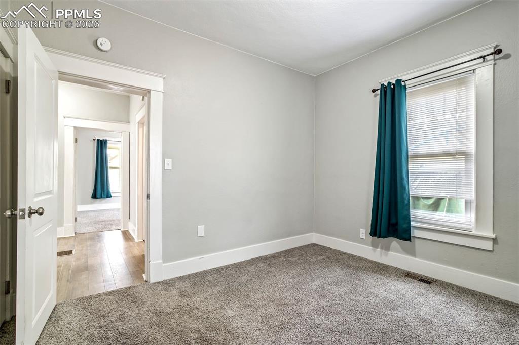 Image 13 of 38: Well-sized bedroom with fresh paint and updated flooring, offering a comfor