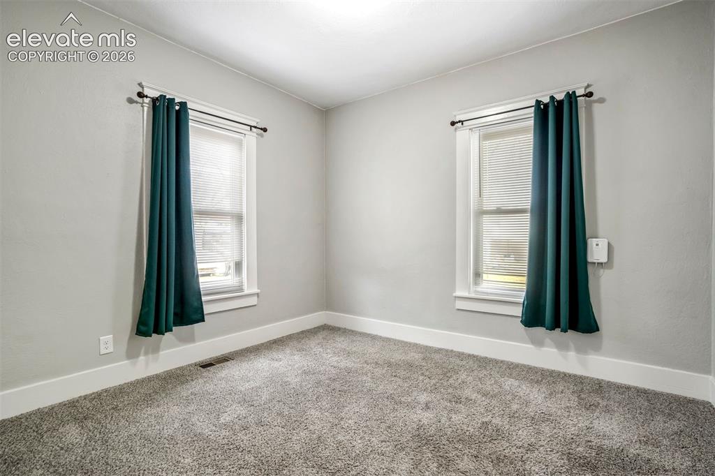 Image 14 of 36: Cozy bedroom with clean finishes, newer carpet, and ample wall space. Ideal