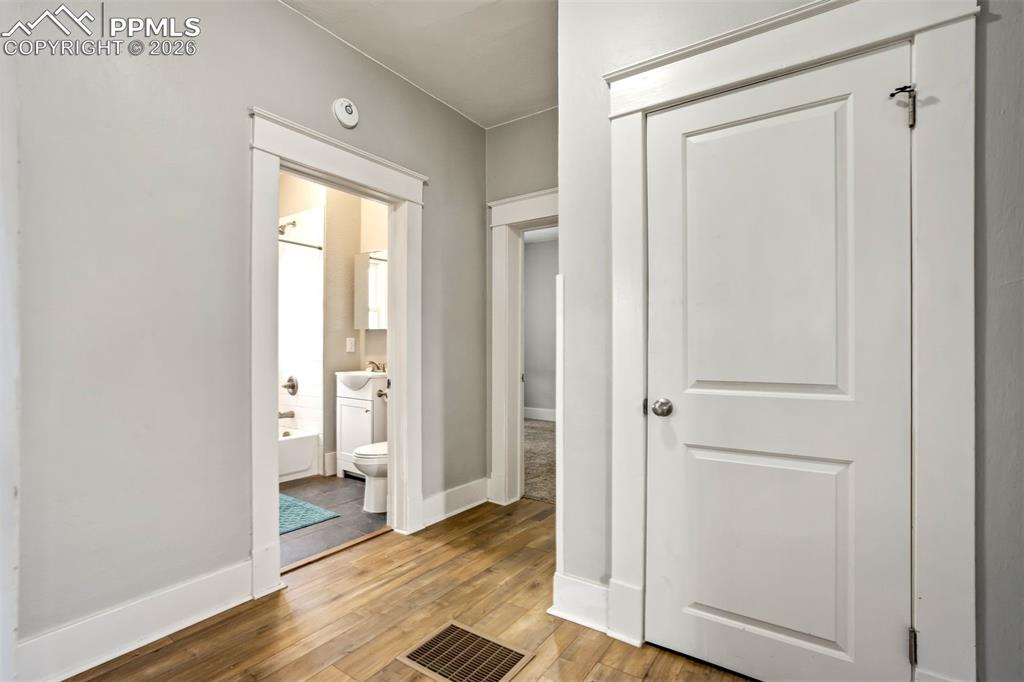 Image 20 of 38: Central hallway provides easy access to bedrooms and bathroom, featuring cl