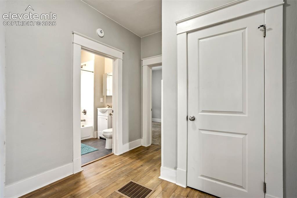 Image 22 of 36: Central hallway provides easy access to bedrooms and bathroom, featuring cl