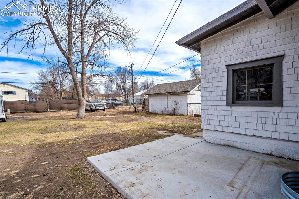 Image 35 of 38: Spacious backyard with mature trees offering shade and character, plus plen
