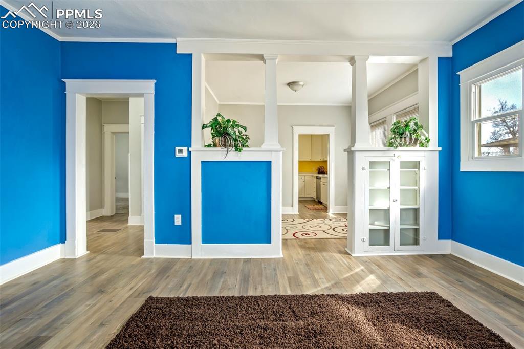 Image 7 of 38: Open-concept feel enhanced by charming built-ins and architectural columns