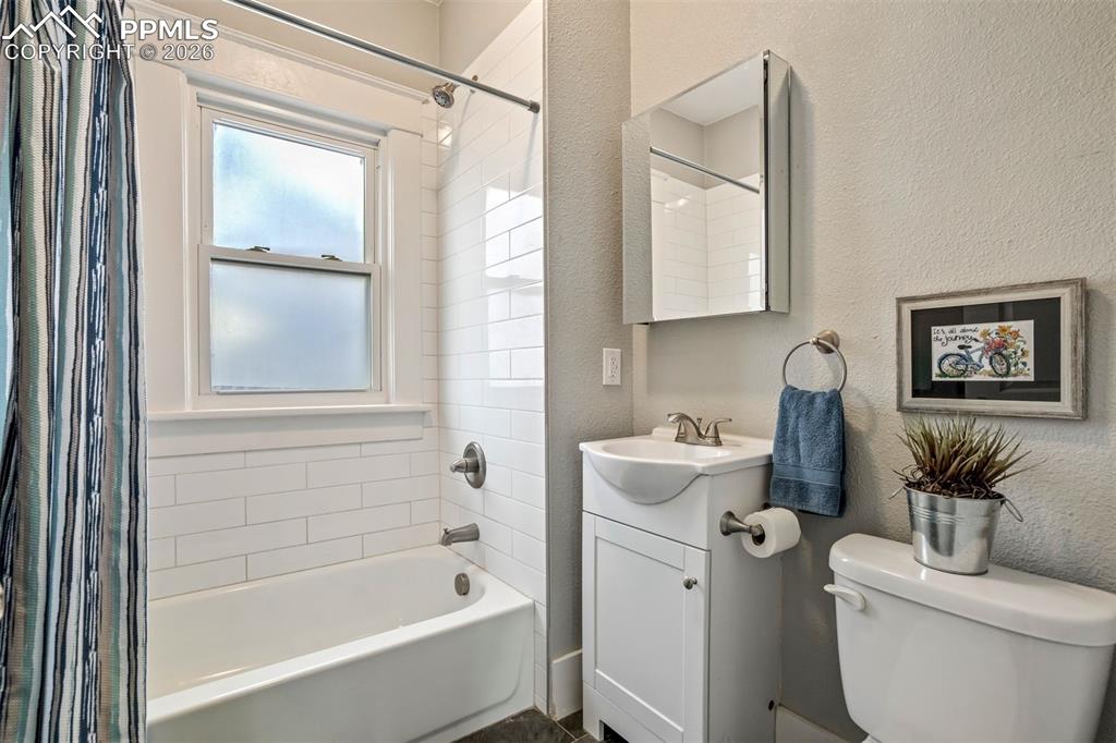 Image 9 of 38: Updated bathroom featuring clean white subway tile surround, modern fixture