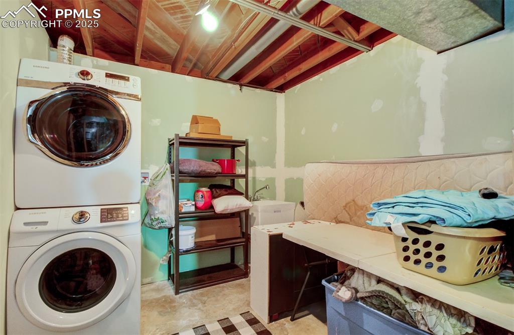 Image 22 of 29: Laundry area with stacked washer / dryer and laundry area