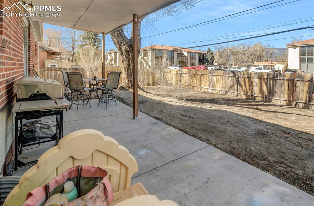 Image 29 of 29: View of patio with a fenced backyard and outdoor dining area