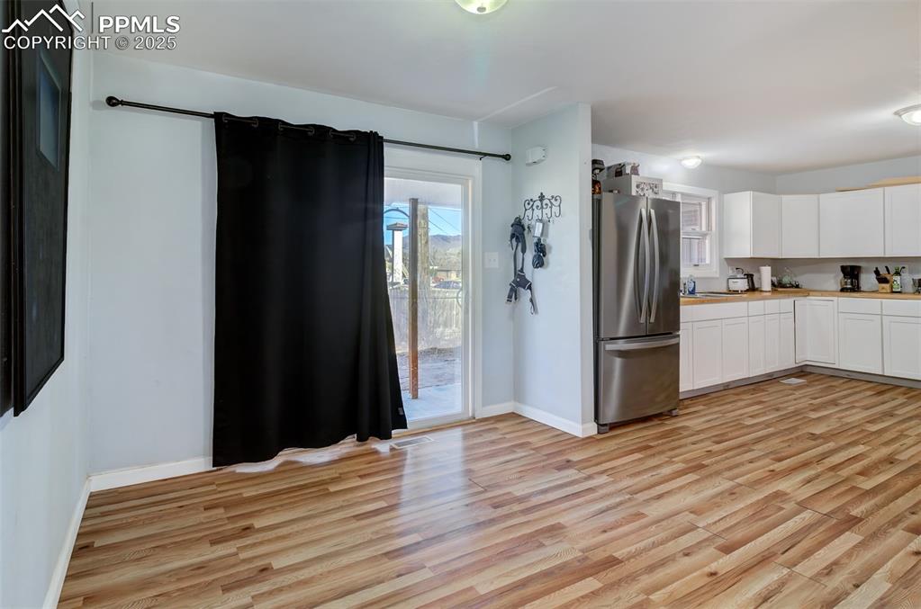 Image 5 of 29: Kitchen with light countertops, light wood finished floors, baseboards, whi