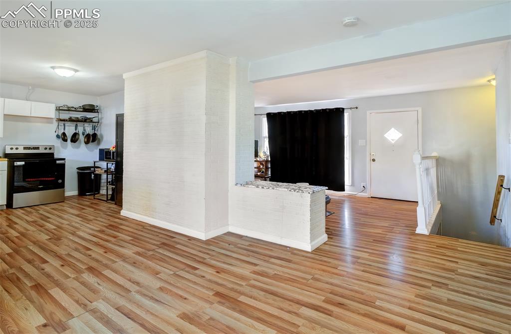 Image 6 of 29: Unfurnished living room with light wood-style flooring