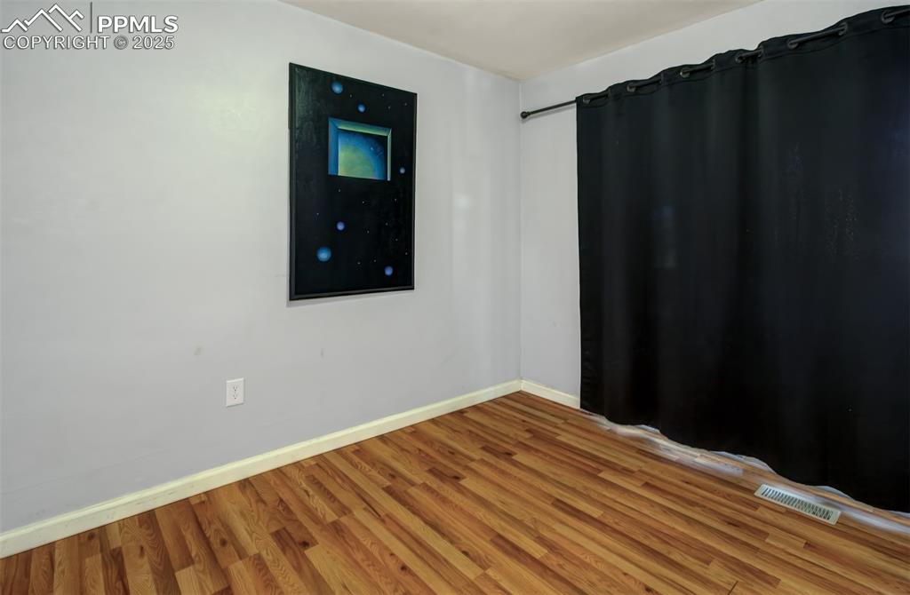 Image 7 of 29: Unfurnished room with baseboards, light wood-style flooring, and visible ve
