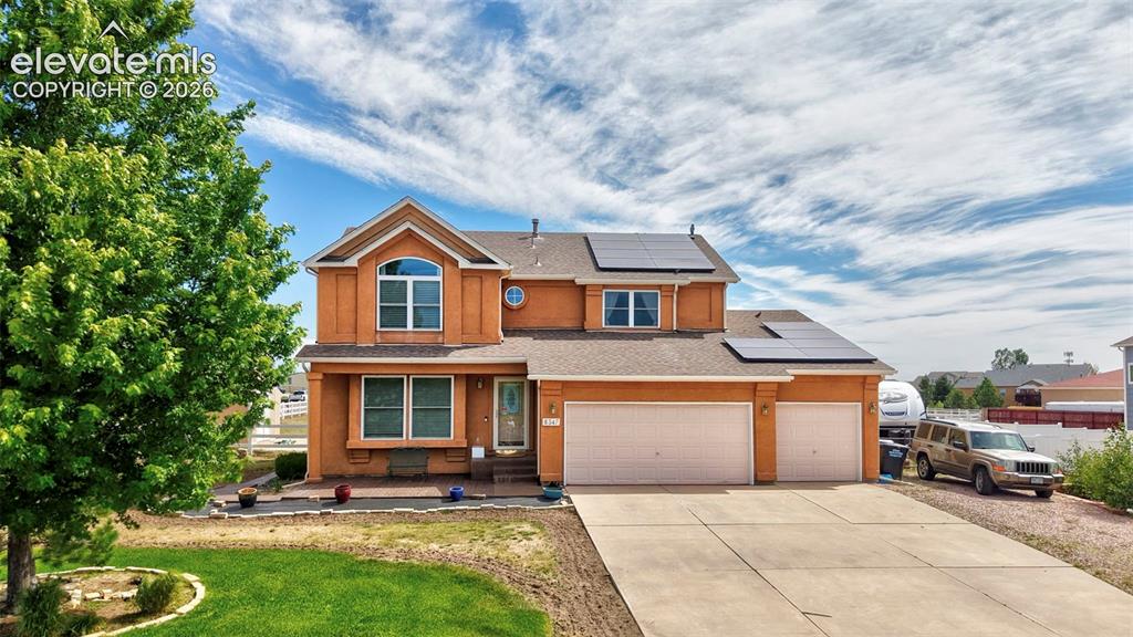 Image 1 of 37: Two-story home featuring a stucco exterior, integrated solar panels, a thre