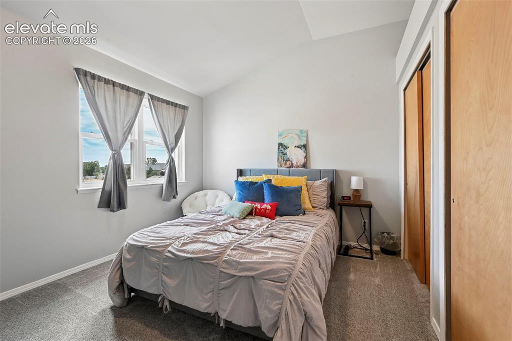 Image 12 of 37: Bedroom featuring light gray walls and a vaulted ceiling