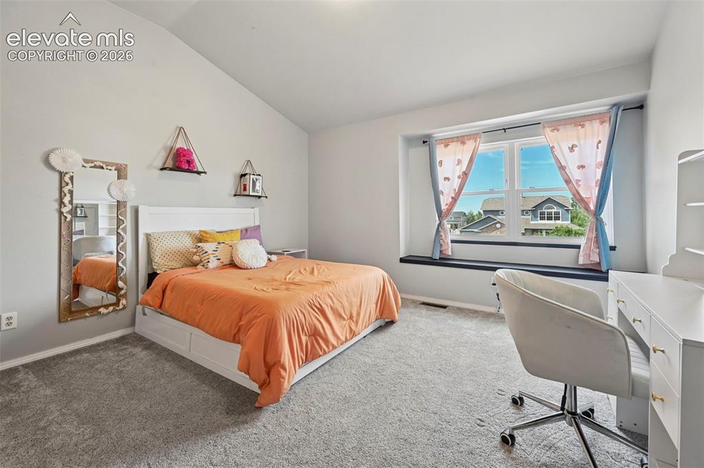 Image 14 of 37: Spacious room with a vaulted ceiling and light gray walls