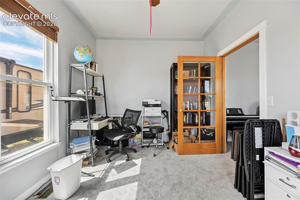 Image 21 of 37: Carpeted room with a large window featuring wood-finish blinds, light gray