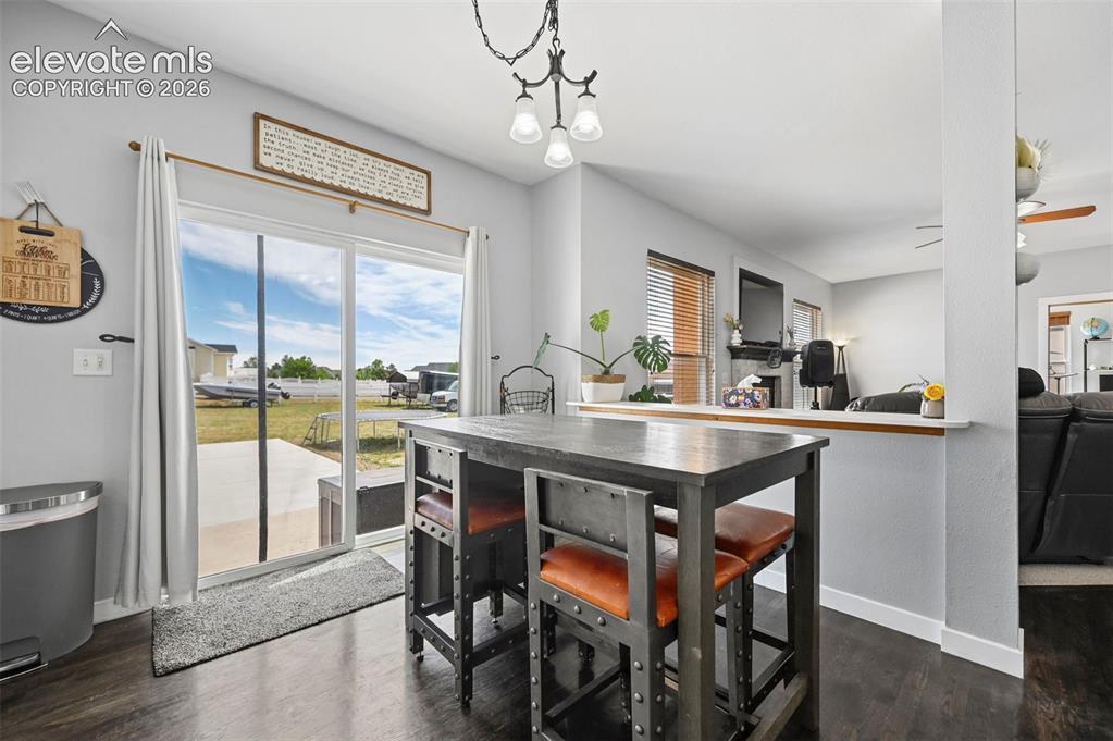 Image 25 of 37: Dining area featuring dark wood-finish flooring and a contemporary pendant