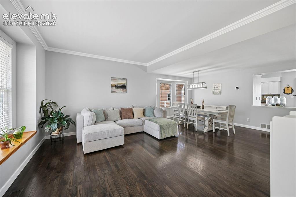 Image 28 of 37: Open-concept interior featuring dark wood-finish flooring, light grey wall