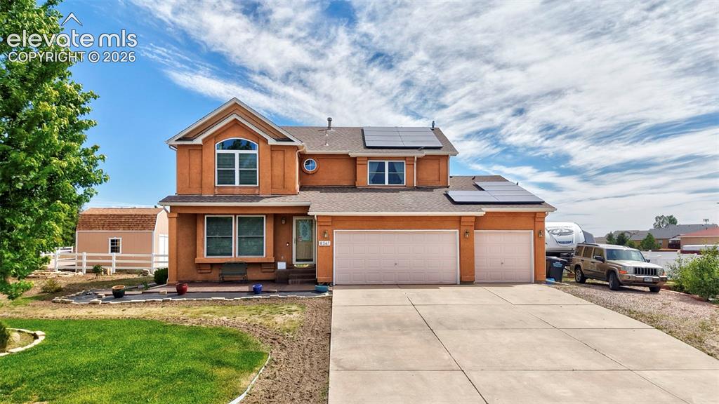 Image 32 of 37: Two-story stucco residence with a concrete driveway, attached two-car garag