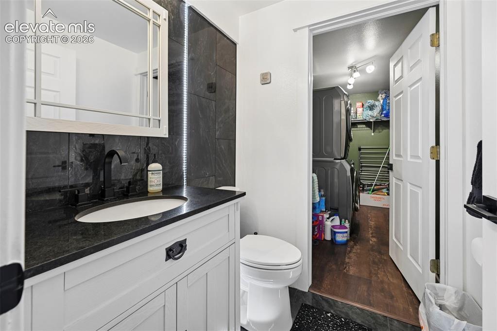 Image 6 of 37: White shaker-style vanity with a dark countertop and integrated sink