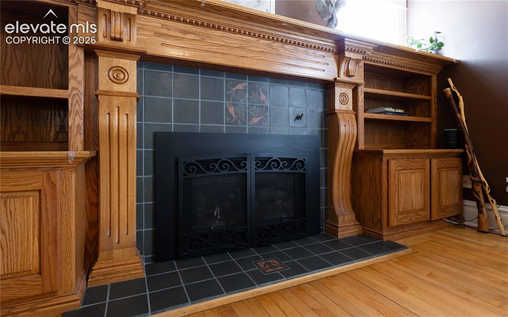 Image 12 of 37: Custom built fireplace inlaid with Van Briggle tile