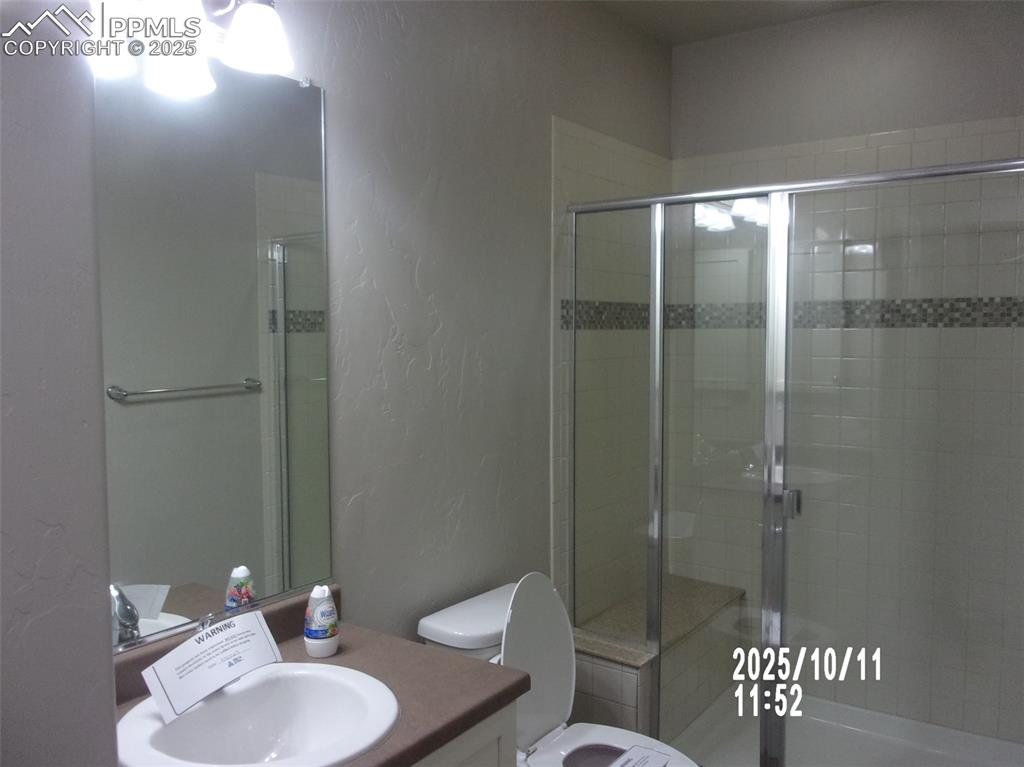 Image 11 of 21: Bathroom with a textured wall, vanity, and a shower stall