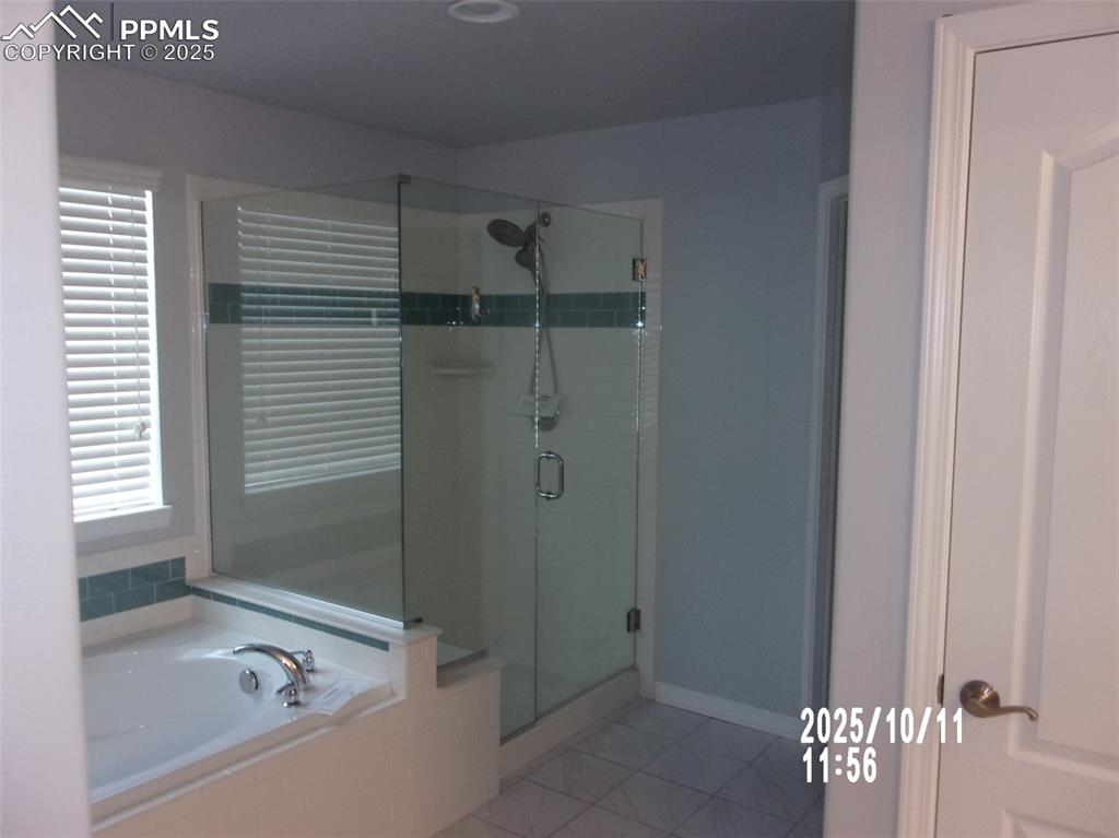 Image 19 of 21: Full bath with a stall shower, a garden tub, and light tile patterned floor