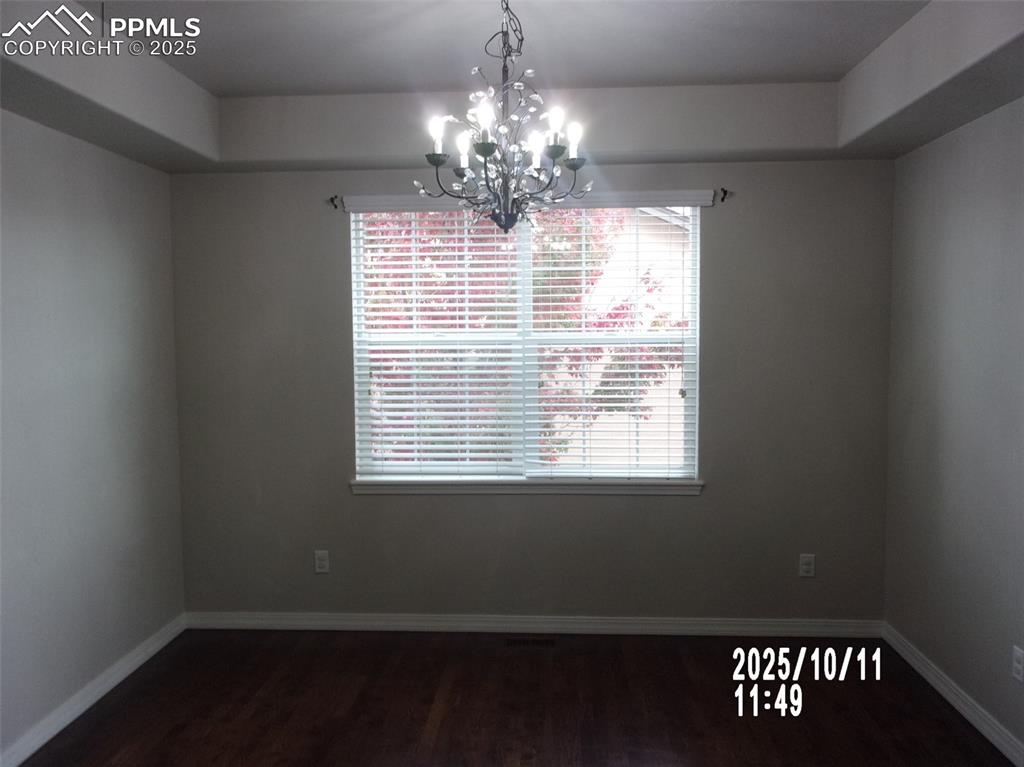 Image 3 of 21: Unfurnished dining area featuring dark wood finished floors and a chandelie