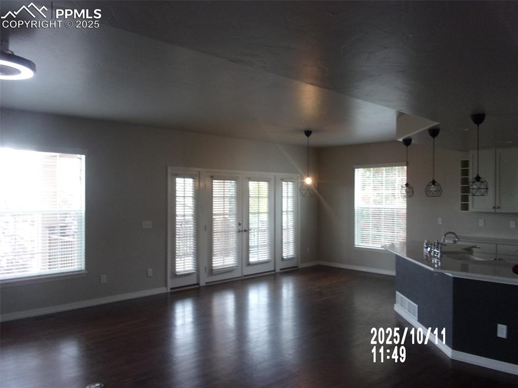 Image 4 of 21: Kitchen featuring pendant lighting, dark wood finished floors, and open flo