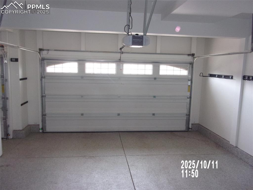 Image 7 of 21: Garage featuring a garage door opener and baseboards