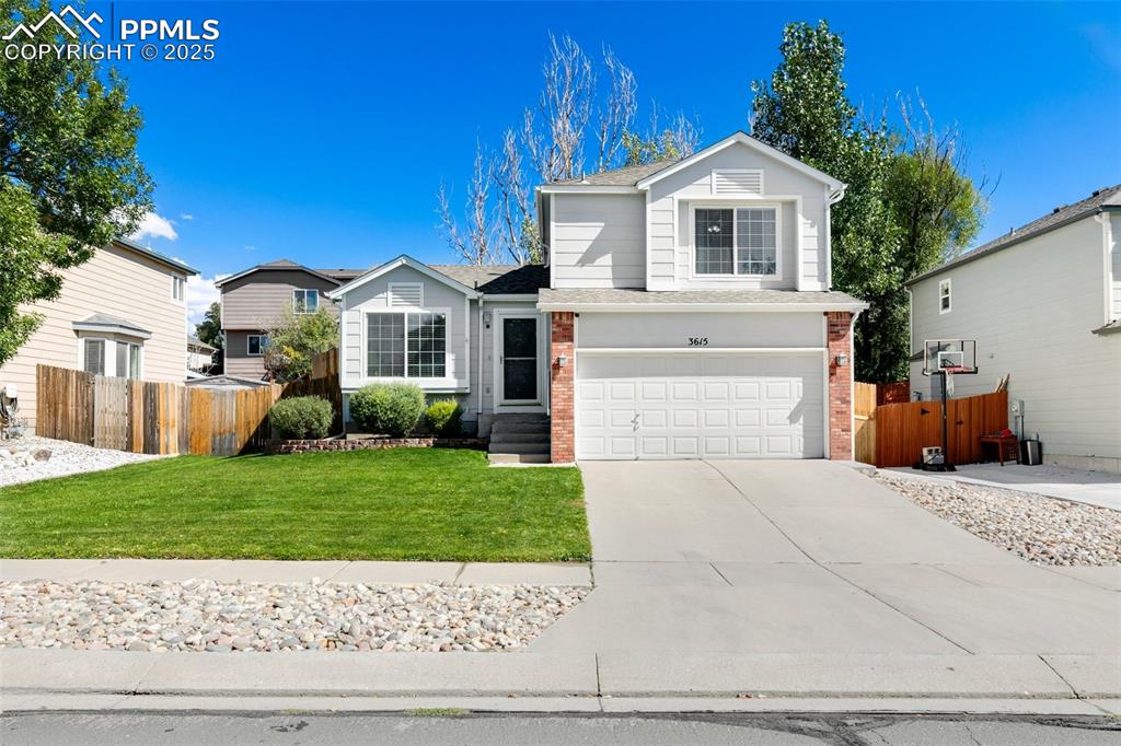 Caption: Traditional-style house with an attached garage, brick siding, concrete driveway, and roof with shin