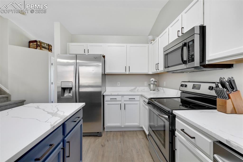 Image 10 of 27: Kitchen featuring appliances with stainless steel finishes, light wood fini