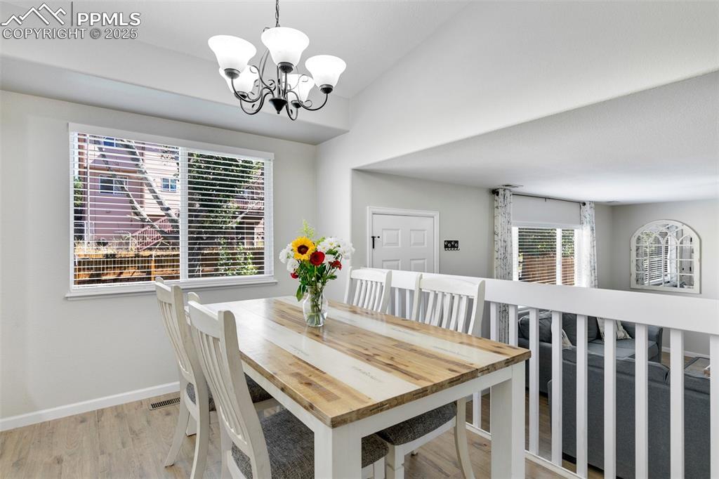 Image 13 of 27: Dining area with light wood-type flooring and a chandelier