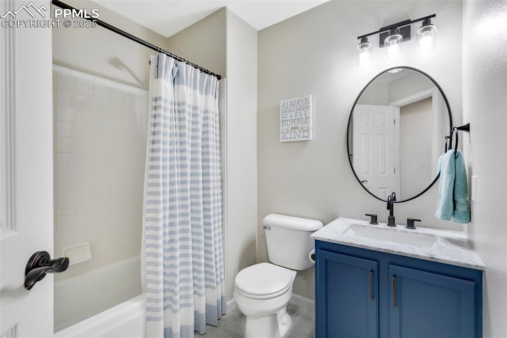 Image 19 of 27: Bathroom with shower / tub combo and vanity