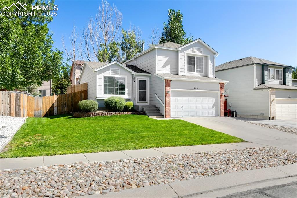 Image 2 of 27: Traditional-style home with driveway, an attached garage, brick siding, and