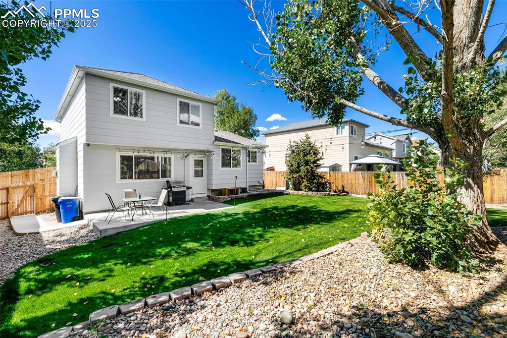 Image 26 of 27: Back of house featuring a patio area, a fenced backyard, and roof with shin