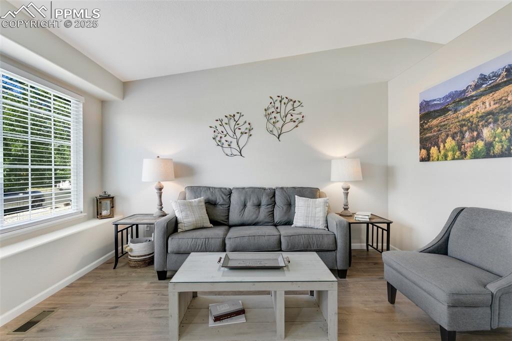 Image 4 of 27: Living area featuring wood finished floors and baseboards