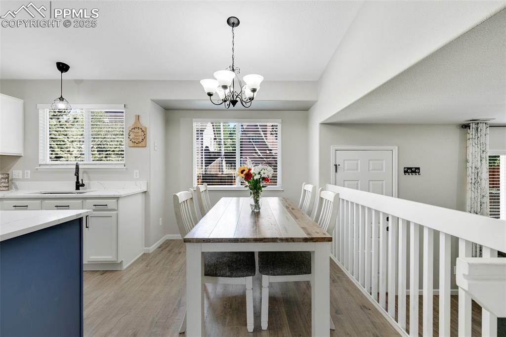 Image 7 of 27: Dining room featuring light wood finished floors and a chandelier