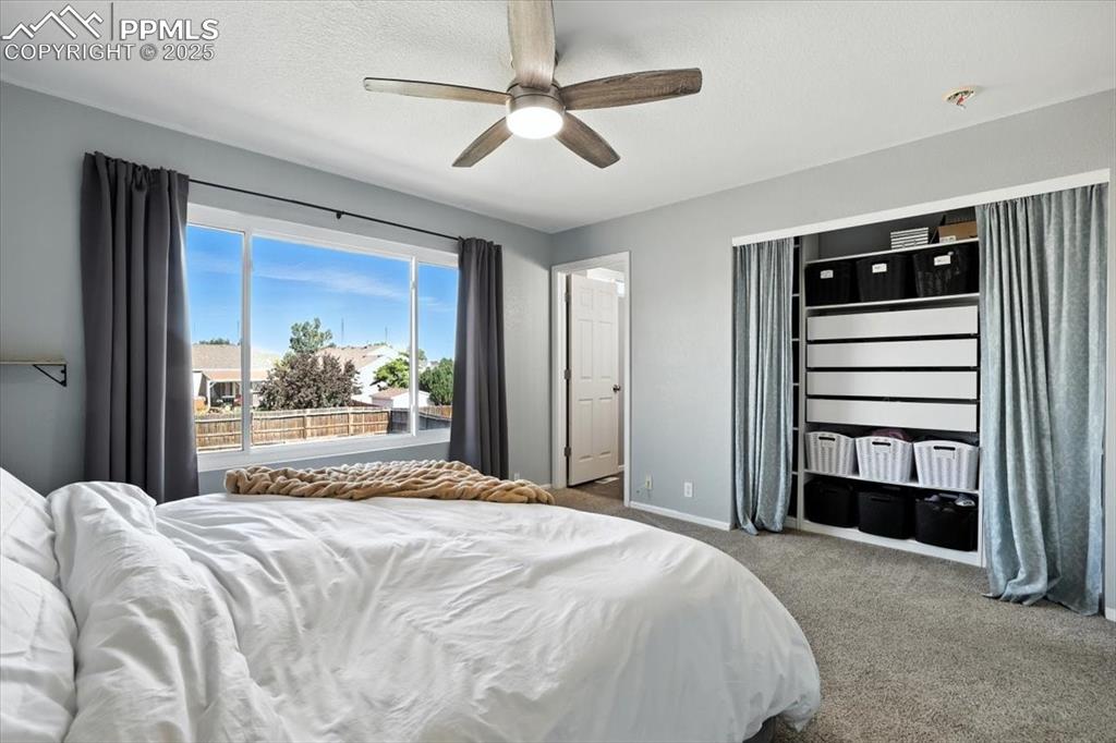 Image 10 of 33: Carpeted bedroom with ceiling fan and a textured ceiling