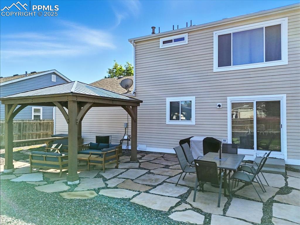 Image 19 of 33: Rear view of property featuring a gazebo, a patio area, and an outdoor livi